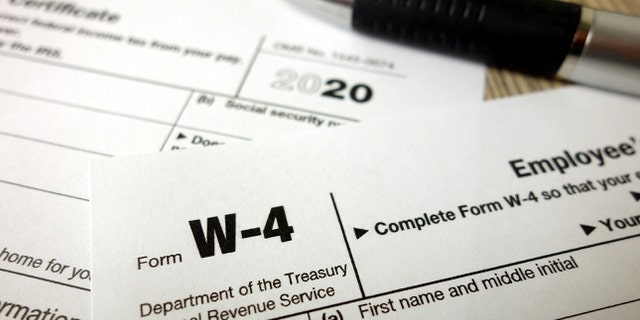 Blank W-4 form and a pen. Tax season