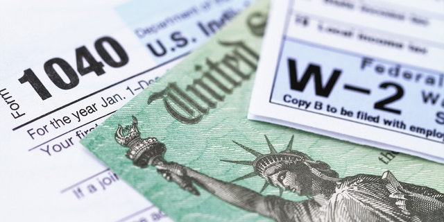 A 1040 income tax form and W-2 pay slip with a federal treasury refund check.