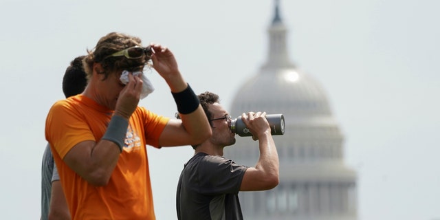 With the U.S. Capitol in the background, players cool off after a game of ultimate frisbee on the National Mall during a heat wave in Washington, U.S., July 20, 2020.