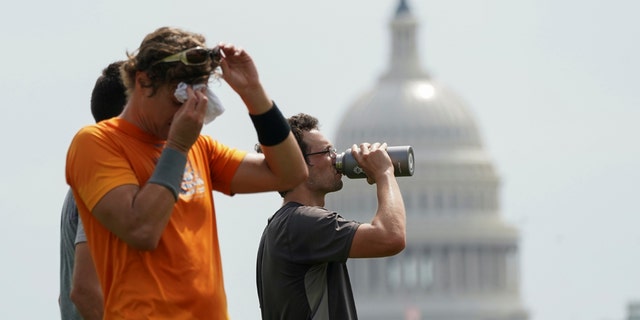 With the U.S. Capitol in the background, players cool off after a game of ultimate frisbee on the National Mall during a heat wave in Washington, U.S., July 20, 2020.
