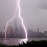 Two lightning bolts frame One World Trade Center as they hit the Hudson River in front of the skyline of lower Manhattan during a thunderstorm in New York City, July 6, 2020.