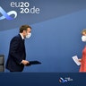 German Chancellor Angela Merkel and French President Emmanuel Macron prepare to address a media conference at the end of an EU summit in Brussels, July 21, 2020. 