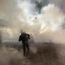 A demonstrator throws a tear gas canister back at federal officers during a Black Lives Matter protest at the Mark O. Hatfield U.S. Courthouse Tuesday, July 28, 2020, in Portland, Ore.