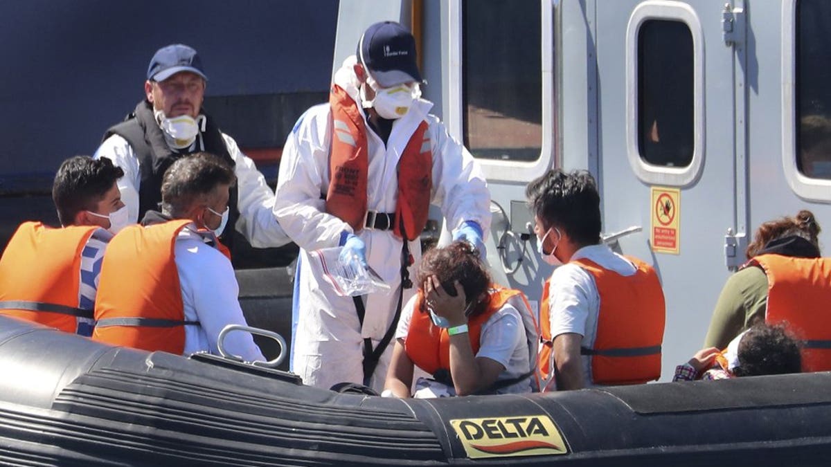 A Border Force vessel brings a group of people thought to be migrants into the port city of Dover, England, from small boats, Friday Aug. 7, 2020. The British government says it will strengthen border measures as calm summer weather has prompted a record number of people to attempt the risky sea crossing in small vessels, from northern France to England.