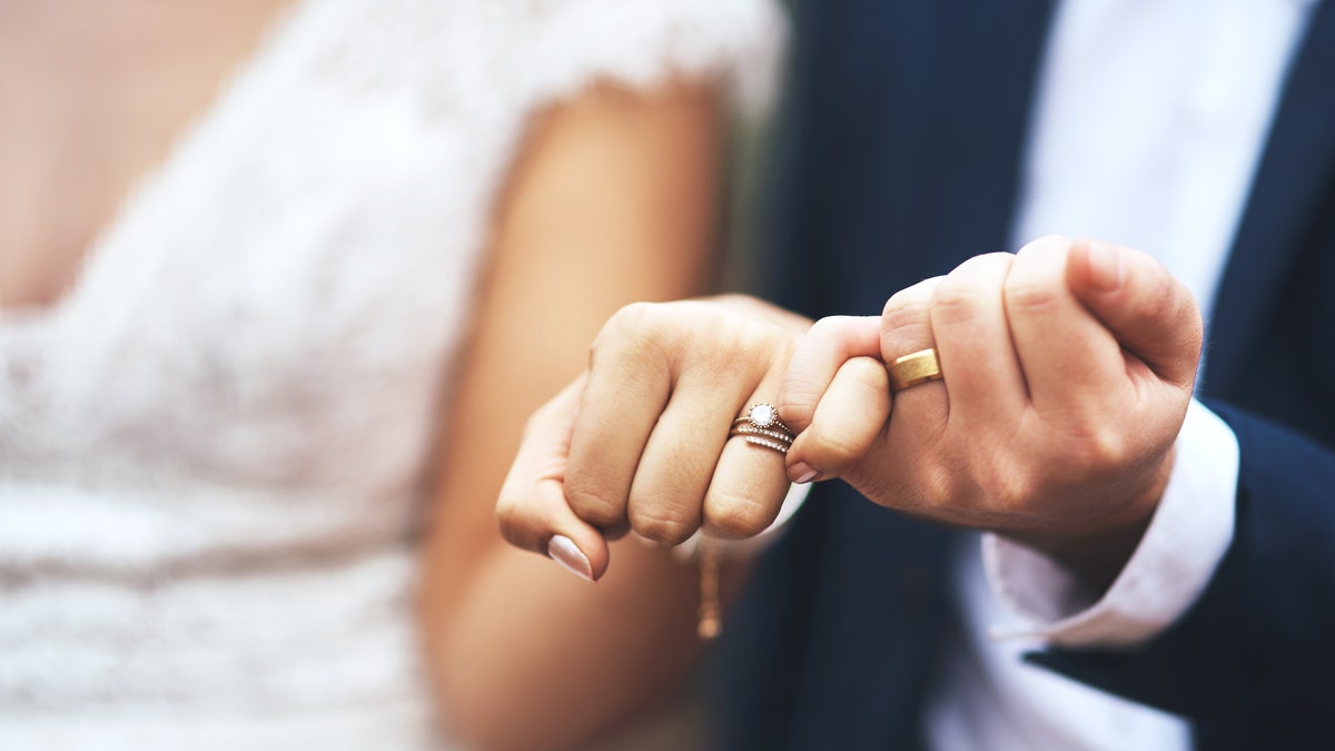 Close-up das mãos dos noivos no dia do casamento