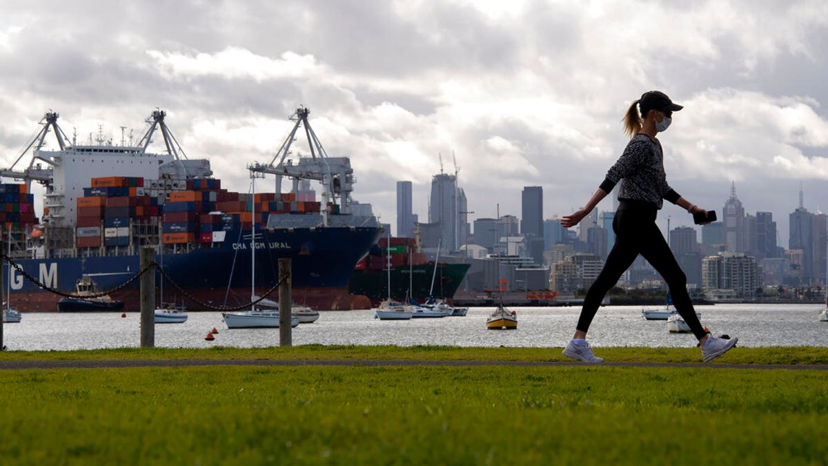 A woman takes a walk in a park during lockdown due to the continuing spread of the coronavirus in Melbourne, Thursday, Aug. 6, 2020. 