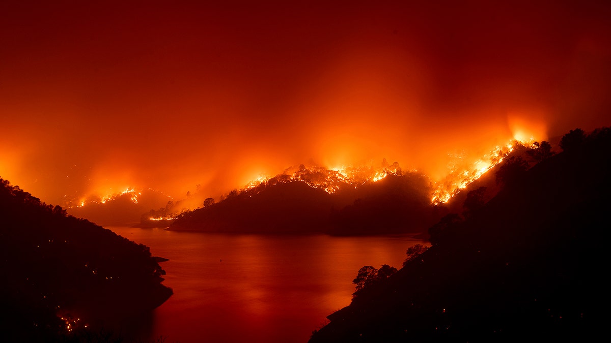 Flames from the LNU Lightning Complex fires burn around Lake Berryessa in unincorporated Napa County, Calif., on Wednesday, Aug. 19, 2020.