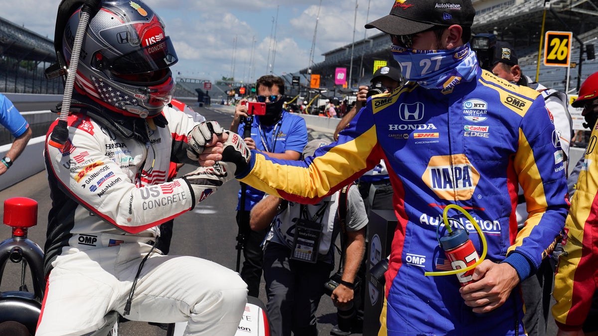 Rossi, wearing blue, congratulates teammate Marco Andretti for winning the Indy 500 pole.