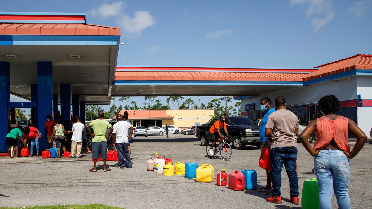 Residents wait in line to fill their containers with gasoline before the arrival of Hurricane Isaias in Freeport, Grand Bahama, Bahamas, Friday, July 31, 2020. (AP Photo/Tim Aylen)