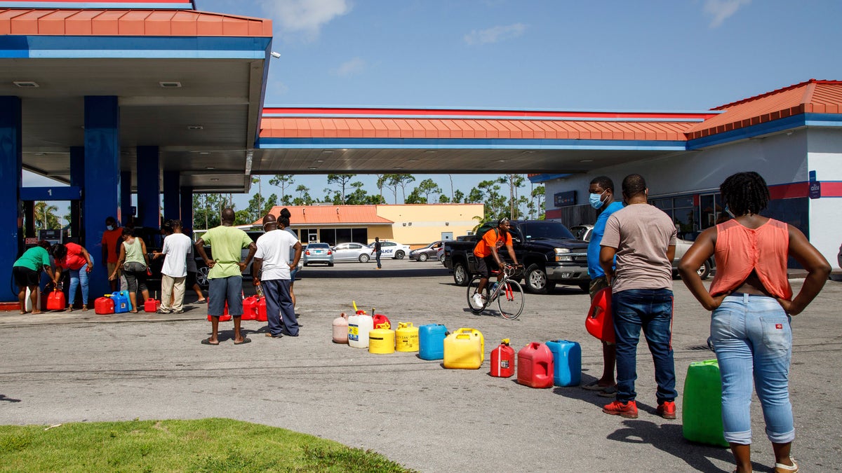 Residents wait in line to fill their containers with gasoline before the arrival of Hurricane Isaias in Freeport, Grand Bahama, Bahamas, Friday, July 31, 2020. (AP Photo/Tim Aylen)