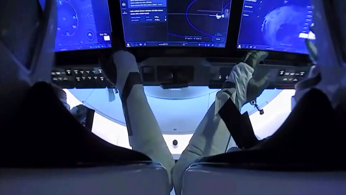 In this image from video made available by NASA, astronauts Doug Hurley, left, and Bob Behnken prepare for undocking from the International Space Station, aboard the SpaceX Crew Dragon capsule on Saturday, Aug. 1, 2020. (NASA via AP)