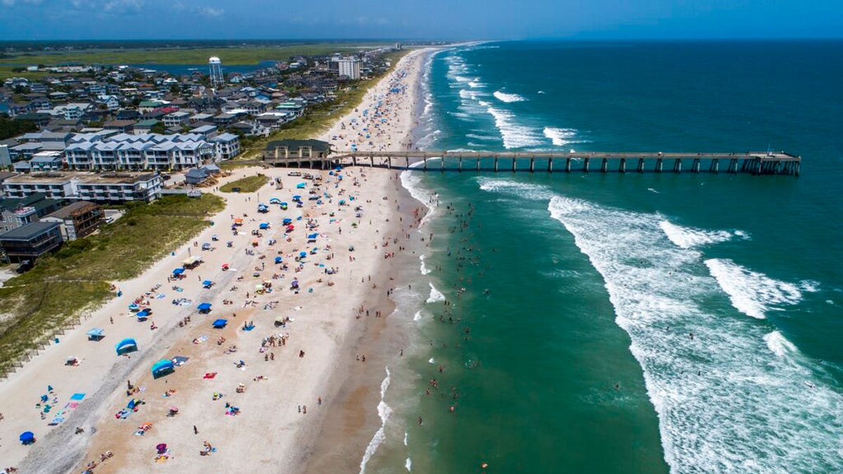 Beachgoers pack Wrightsville Beach, N.C., Sunday, Aug. 2, 2020 as Tropical Storm Isaias moves along the Southeast Coast. 