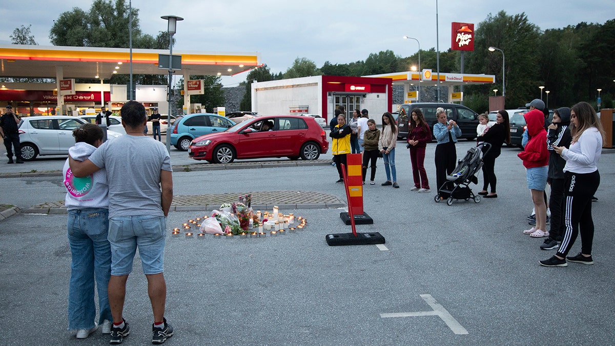 Flowers and candles are placed Sunday Aug. 2, 2020 near where a twelve-year-old girl was shot and killed near a petrol station in Botkyrka, south of Stockholm, Sweden. (Ali Lorestani//TT via AP)
