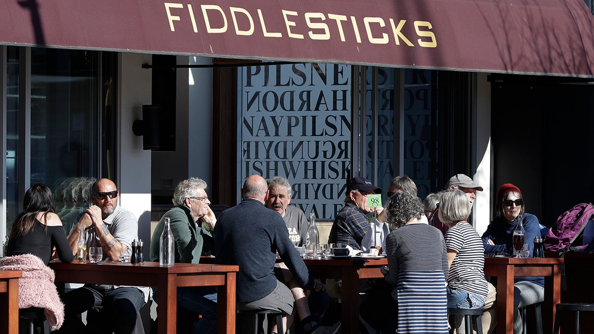 Customers at a cafe enjoy lunch in the sunshine in Christchurch, New Zealand, Sunday, Aug. 9, 2020. New Zealand marked a 100 days of being free from the coronavirus in its communities Sunday, Aug. 9, with just a handful of infections continuing to be picked up at the border where people are quarantined. (AP Photo/Mark Baker)