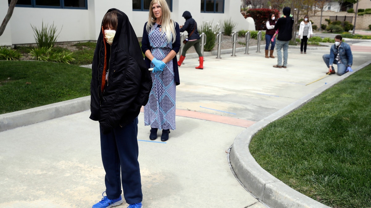 Worshipers line up to take communion on Palm Sunday outside of Godspeak Calvary Chapel in Newbury Park, Calif on April 5, 2020. (AP Photo/Marcio Jose Sanchez, File)