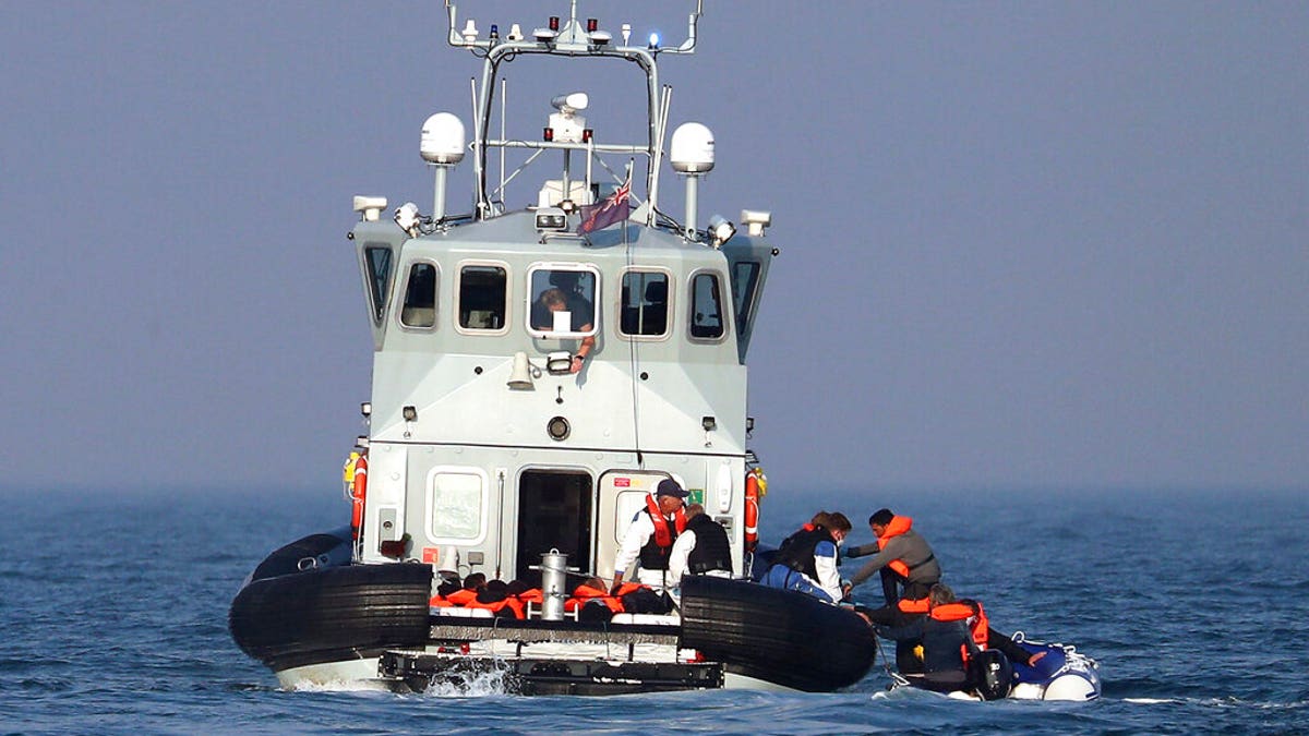 A Border Force vessel assist a group of people thought to be migrants on board from their inflatable dinghy in the Channel, Monday Aug. 10, 2020.(Gareth Fuller/PA via AP)