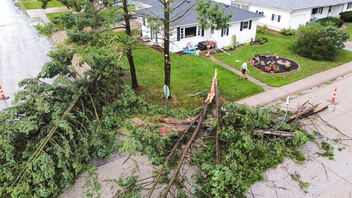 Downed trees and a utility pole in front of the home of Tim and Patricia Terres in Walcott, Iowa after high winds and heavy rain passed through the area Monday, Aug. 10, 2020, in Davenport, Iowa. 