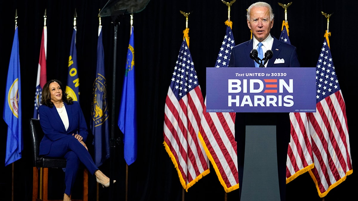 Democratic presidential candidate former Vice President Joe Biden speaks as his running mate Sen. Kamala Harris, D-Calif., listens during a news conference at Alexis Dupont High School in Wilmington, Del., Wednesday, Aug. 12, 2020. (AP Photo/Carolyn Kaster)