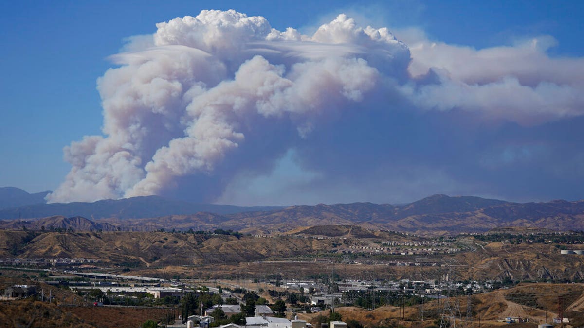 The Lake Fire sends a plume of smoke over the Angeles National Forest Wednesday, Aug. 12, 2020, in a view from Santa Clarita, Calif. (AP Photo/Marcio Jose Sanchez)