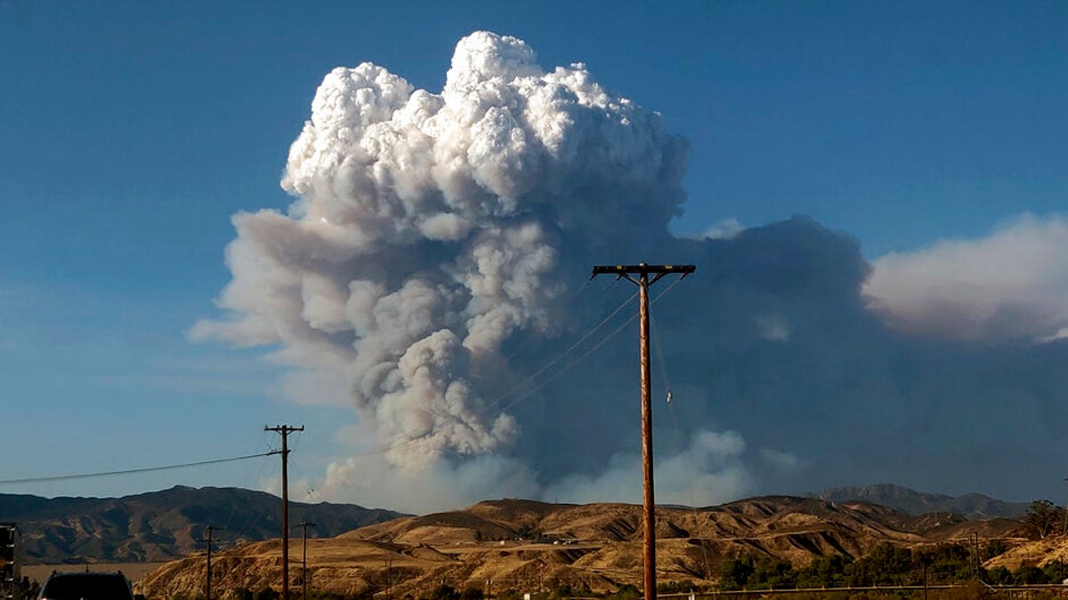 The Lake Hughes fire sends a plume of smoke over Angeles National Forest on Wednesday, Aug. 12, 2020, in a view from Santa Clarita, Calif. (AP Photo/Ringo H.W. Chiu)