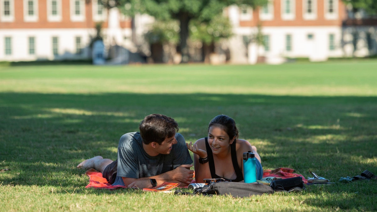 Students sit in partial shade on the quad at the University of Alabama on Saturday, Aug. 15, 2020, in Tuscaloosa, Ala. More than 20,000 students returned to campus Saturday for the first time since spring break. (AP Photo/Vasha Hunt)