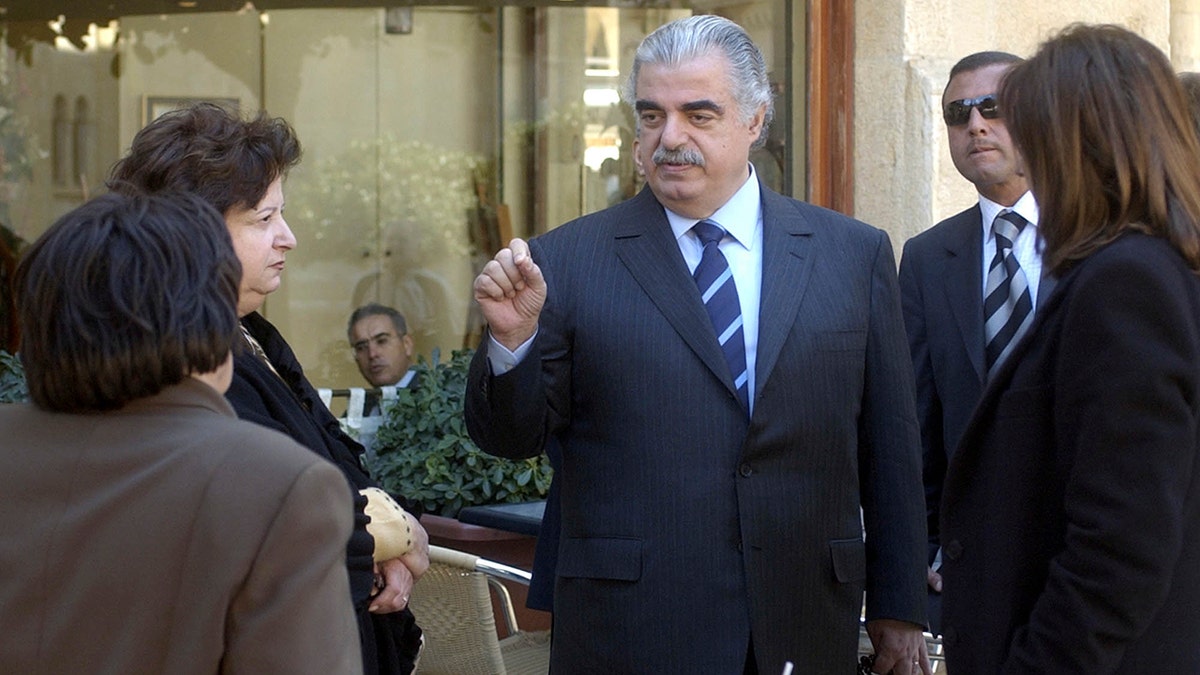 FILE - In this Feb. 14, 2005 file photo, former Lebanese Prime Minister Rafik Hariri, center, speaks to people outside the Lebanese Parliament minutes before an explosion killed him and 22 others, in Beirut, Lebanon. More than 15 years after the truck bomb assassination of Hariri in Beirut, a U.N.-backed tribunal in the Netherlands is announcing verdicts this week in the trial of four members of the militant group Hezbollah allegedly involved in the killing. (AP Photo, File)