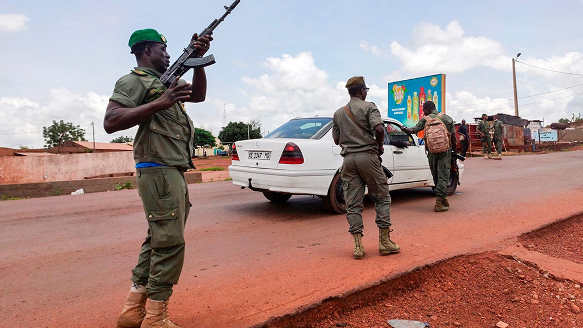 Malian soldiers check a vehicle in the garrison town of Kati, Mali, on Tuesday, Aug. 18, 2020. Malian soldiers took up arms and began detaining senior military officers in an apparent mutiny, raising fears of a potential coup after several months of anti-government demonstrations calling for the president's resignation.