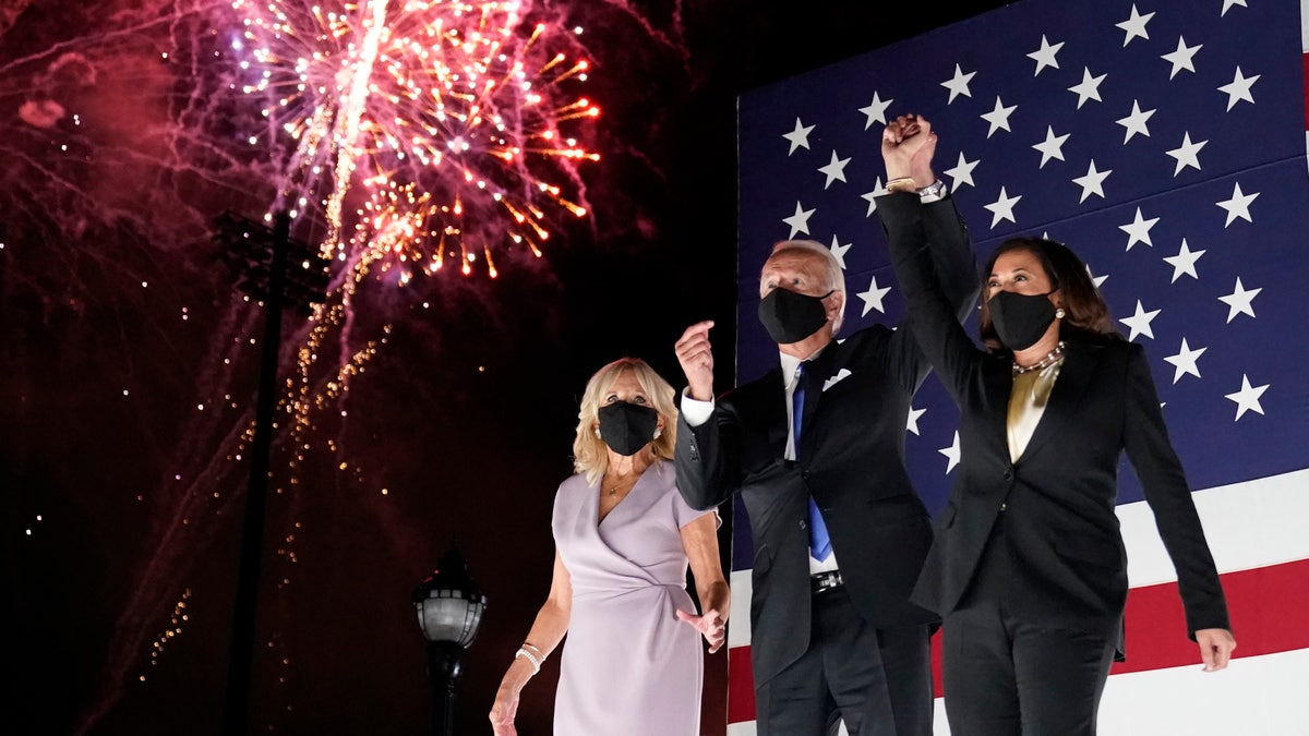Democratic presidential candidate former Vice President Joe Biden and his running mate Sen. Kamala Harris, D-Calif., join hands as they watch fireworks during the fourth day of the Democratic National Convention, Thursday, Aug. 20, 2020, at the Chase Center in Wilmington, Del. Jill Biden is at left. (AP Photo/Andrew Harnik)