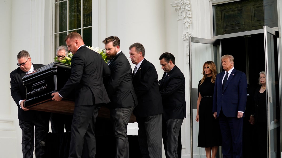 President Donald Trump and first lady Melania Trump hold hands as they watch people carry the casket of Robert Trump out of the White House after a memorial service for the president's younger brother on Friday, Aug 21, 2020, in Washington. (AP Photo/Evan Vucci)