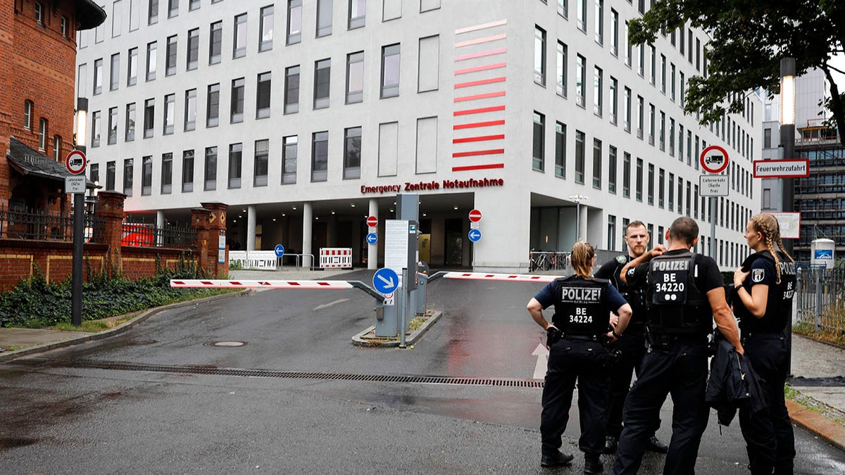 German police officers stand in front of the emergency entrance of the Charite hospital where Alexei Navalny is expected to arrive in Berlin, Germany, Saturday, Aug.22, 2020. The dissident who is in a coma after a suspected poisoning has been transferred from the Siberian city of Omsk. Navalny is flown to Germany to receive treatment. (AP Photo/Markus Schreiber)