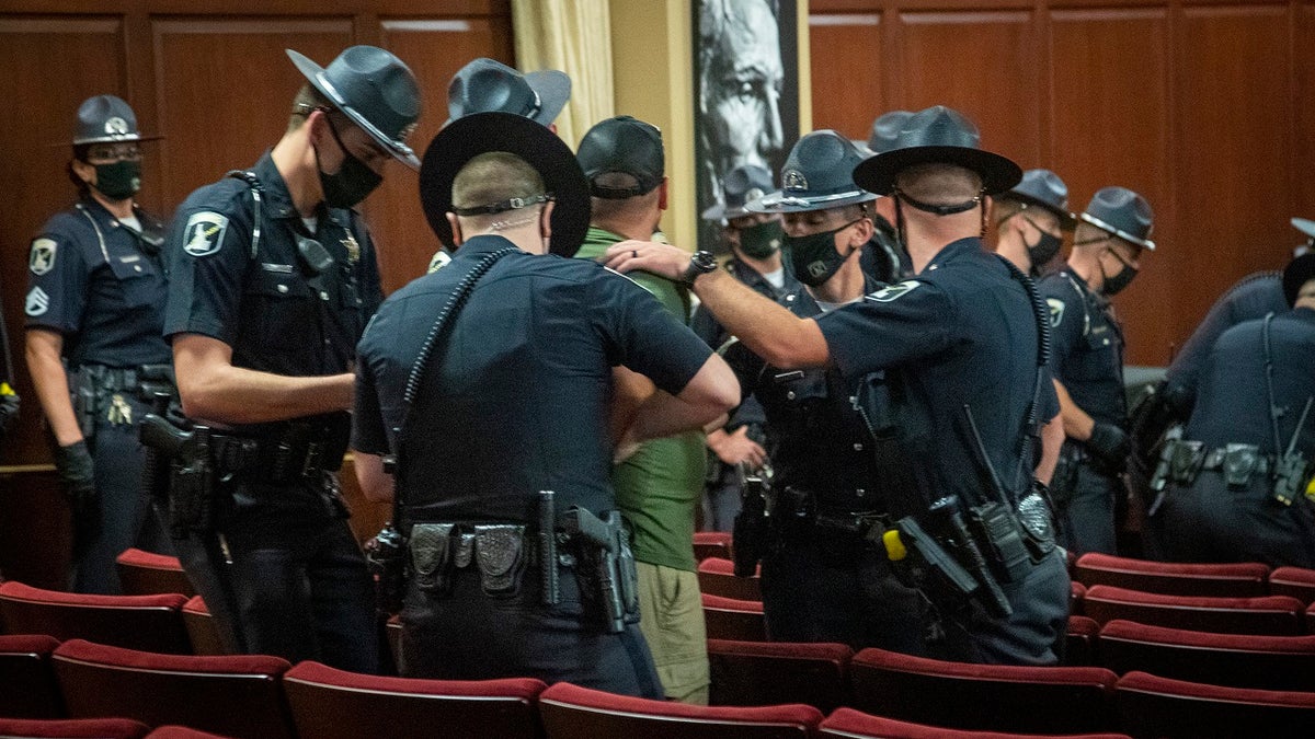 Idaho State Police arrest a man who refused to leave the Lincoln Auditorium in the Idaho State Capitol on Tuesday in Boise, Idaho. (Katherine Jones/Idaho Statesman via AP)