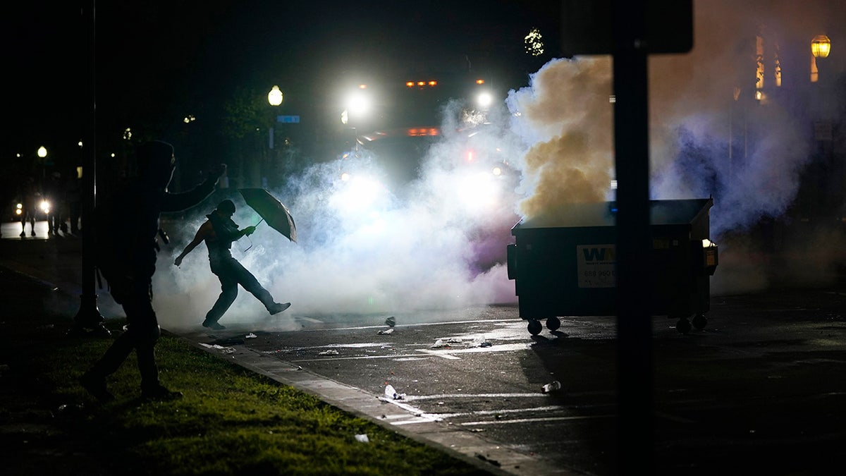 A protester kicking a smoke canister Tuesday in Kenosha, Wis. Anger over the Sunday shooting of Jacob Blake, a Black man, by police spilled into the streets for a third night.