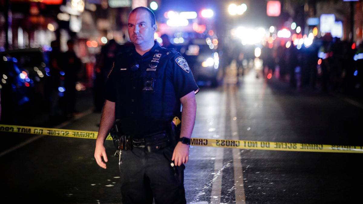 A New York City police officer stands on a street at the scene of a shooting in the Brooklyn borough of New York. June 4, 2020. (AP Photo/Frank Franklin II, File)