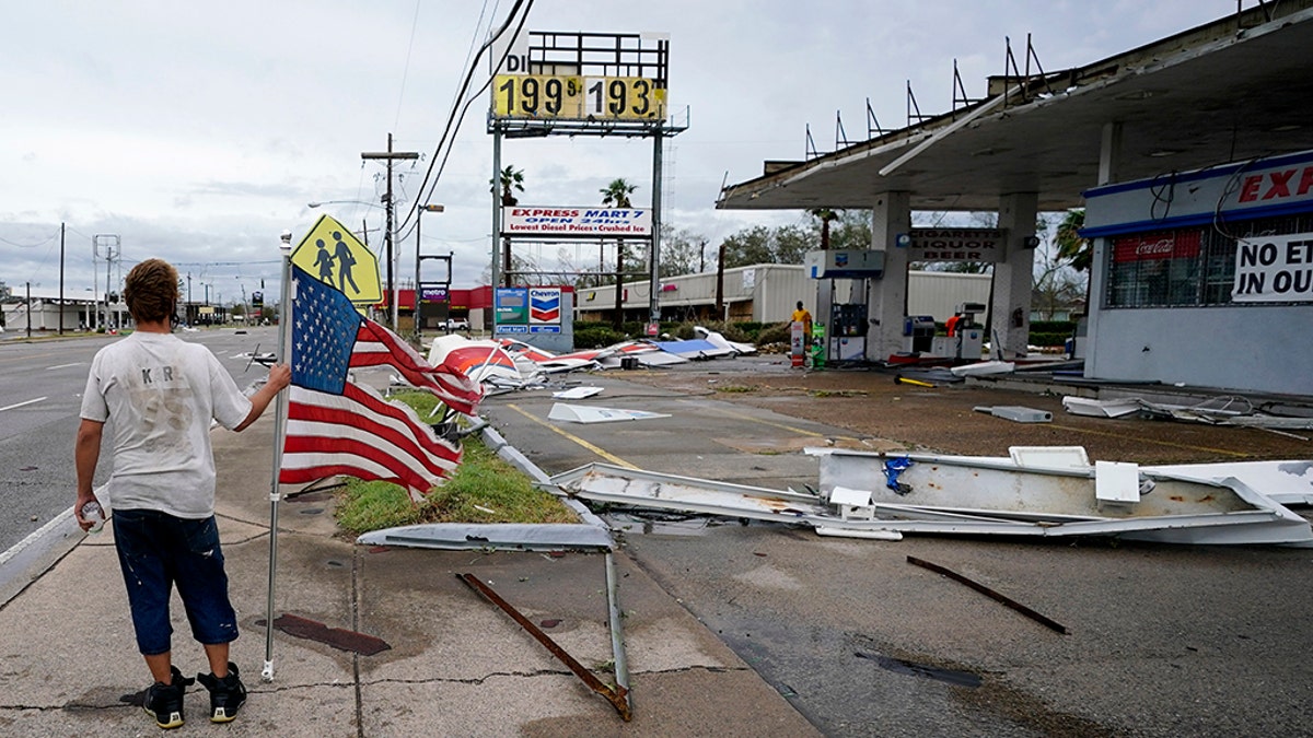Dustin Amos walks near debris at a gas station on Aug. 27, in Lake Charles, La., after Hurricane Laura moved through the state. (AP Photo/Gerald Herbert)
