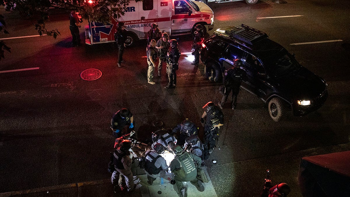 A man is treated by medics after being shot during a confrontation on Saturday, Aug. 29, 2020, in Portland, Ore. Fights broke out in downtown Portland as a large caravan of supporters of President Donald Trump drove through the city, clashing with counter-protesters. (AP Photo/Paula Bronstein)