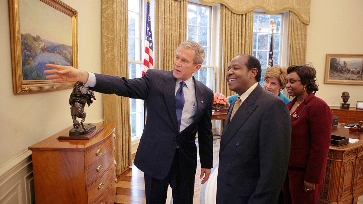 In this Thursday, Feb. 17, 2005, file photo provided by the White House, President Bush, left, and first lady Laura Bush, second right, meet with Paul Rusesabagina, center-right, and his wife, Tatiana, right, in the Oval Office. (Eric Draper/The White House via AP )