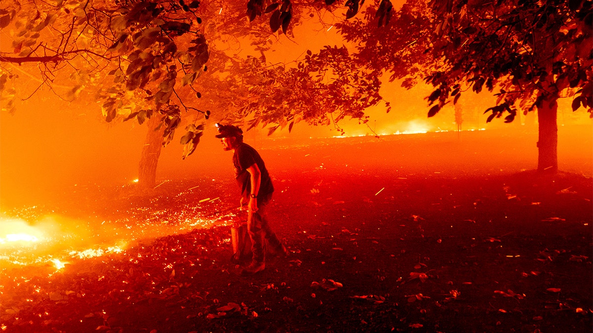 Matt Nichols tries to save his home as the LNU Lightning Complex fires tear through Vacaville, Calif., on Aug. 19. Fire crews across the region scrambled to contain dozens of wildfires sparked by lightning strikes as a statewide heat wave continues. (AP Photo/Noah Berger)