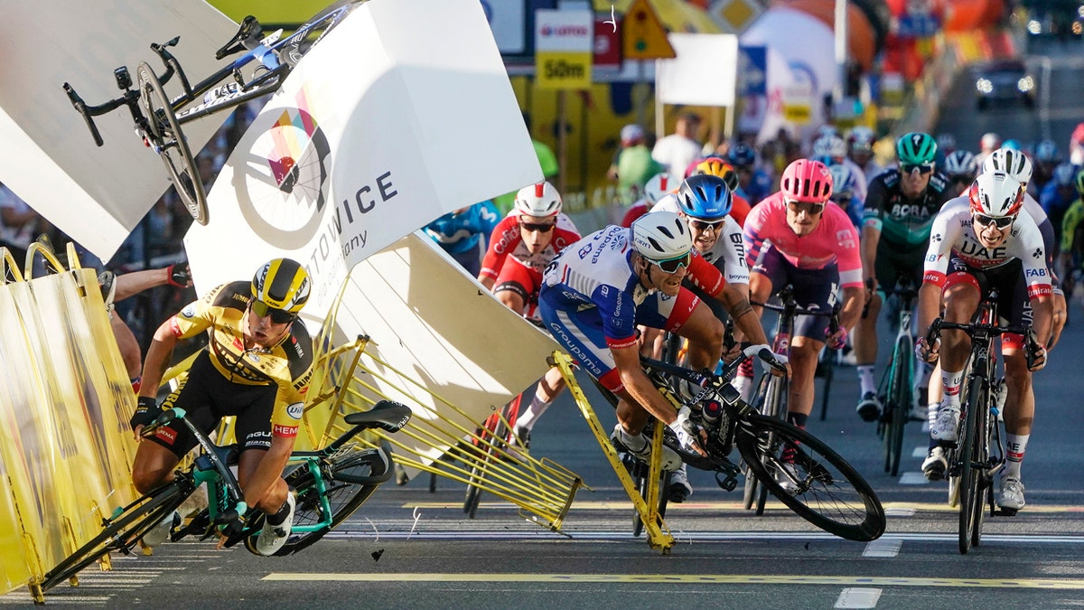 Dutch cyclist Dylan Groenewegen crashes to the ground as a bicycle is flying overhead in a major collision on the final stretch of the opening stage of the Tour de Pologne race in Katowice, Poland, Wednesday, Aug. 5, 2020. (AP Photo/Tomasz Markowski)<br>