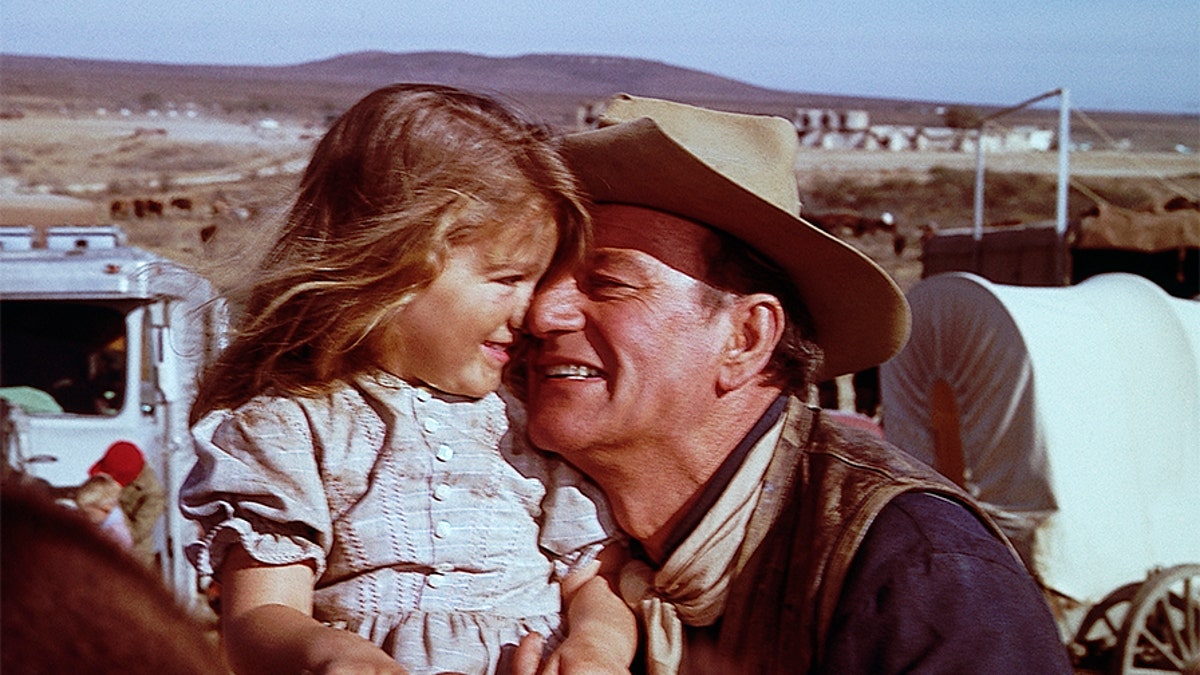 John Wayne hugs his daughter, Aissa, on the set of 'The Alamo.'