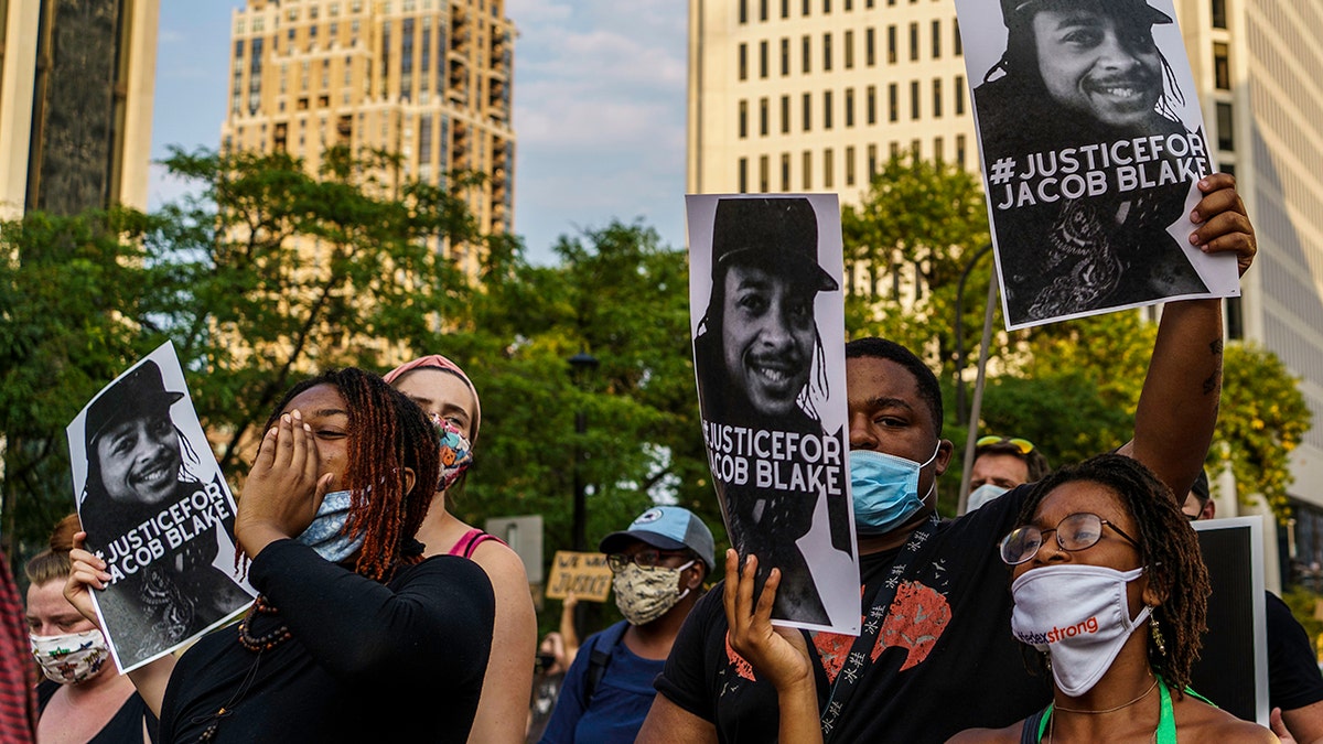 Protesters hold signs outside the Minneapolis 1st Police precinct during a demonstration against police brutality and racism on August 24, 2020 in Minneapolis, Minnesota. (KEREM YUCEL/AFP via Getty Images)