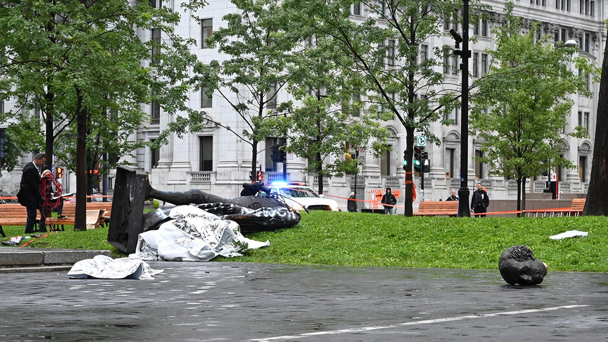 A statue of the first Canadian Prime Minister John A. Macdonald lies on the ground (L), with the statue's head a few meters away, at Canada Park in central Montreal on August 29, 2020, after it was pulled down by anti-racism protesters during a demonstration calling for the defunding of the police. - Macdonald's government has been accused of seeking to assimilate indigenous peoples through forcible enrollment in residential schools, for example, that led to a loss of language and culture -- described in a 2015 reconciliation commission report as "cultural genocide." (Photo by Eric THOMAS / AFP) (Photo by ERIC THOMAS/AFP via Getty Images)