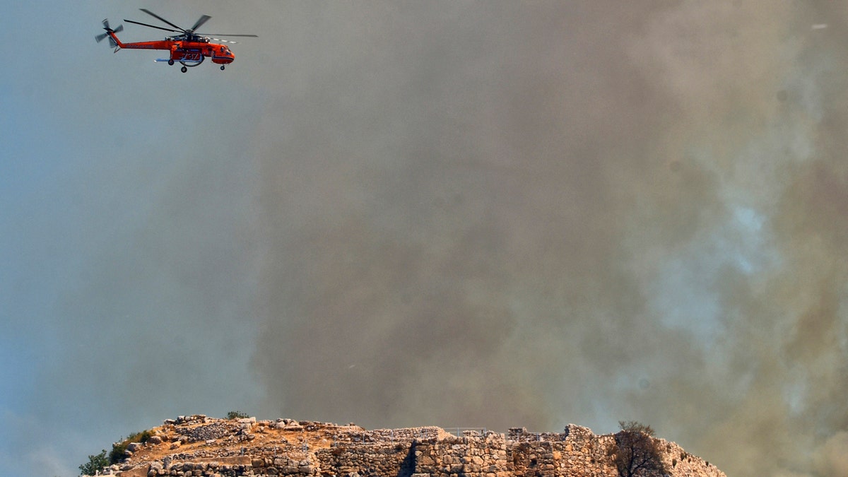 A helicopter operates during a wildfire over the ancient site of Mycenae, Greece, some 90 miles south of Athens, on Sunday, Aug. 30, 2020.