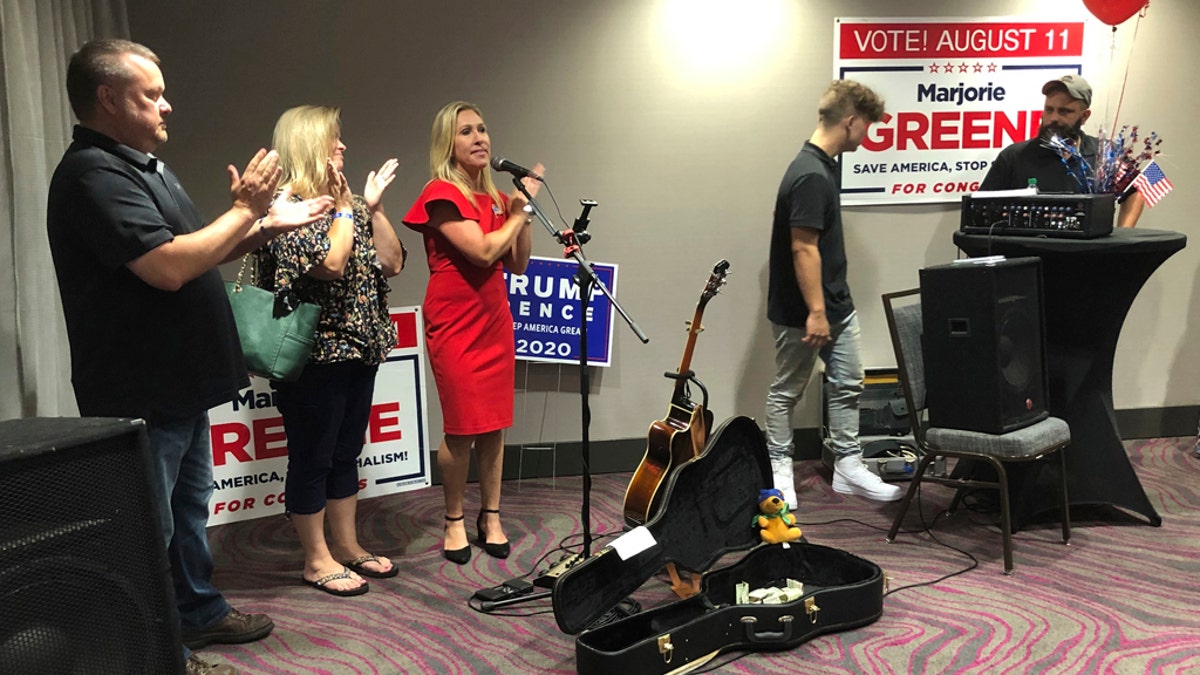 Construction executive Marjorie Taylor Greene, third from left, claps with her supporters at a watch party event, late Tuesday, Aug. 11, 2020, in Rome, Ga. Greene won the GOP nomination for northwest Georgia's 14th Congressional District. (AP Photo/Mike Stewart)