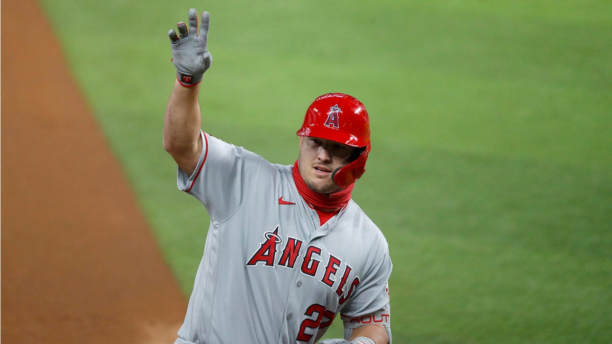 Los Angeles Angels' Mike Trout waves to the dugout after hitting a two-run home run in the first inning of a baseball game against the Texas Rangers in Arlington, Texas, Friday, Aug. 7, 2020. The shot scored David Fletcher. (AP Photo/Tony Gutierrez)