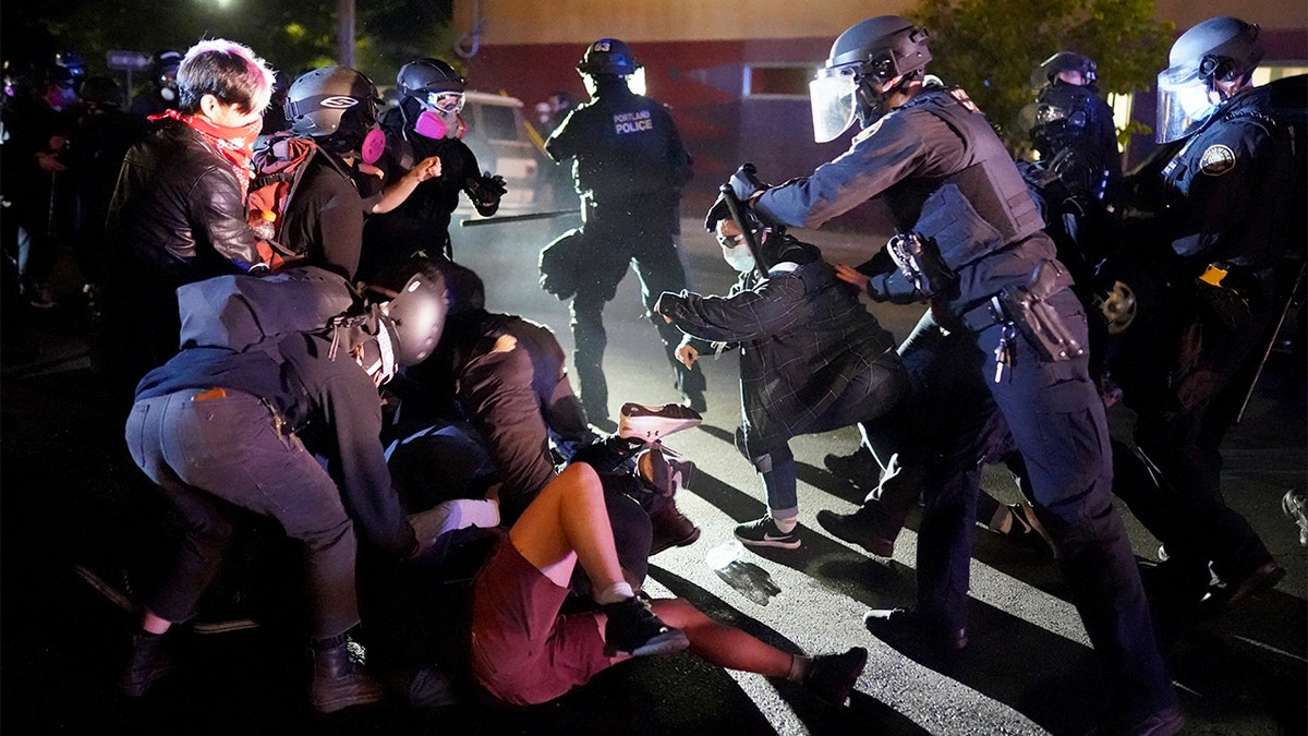 PORTLAND, OR - AUGUST 22: Protesters and Portland police clash while dispersing a crowd gathered in front of the Portland Police Bureau North Precinct early in the morning on August 22, 2020 in Portland, Oregon. Friday marked the 86th night of protests in Portland following the death of George Floyd. (Photo by Nathan Howard/Getty Images)