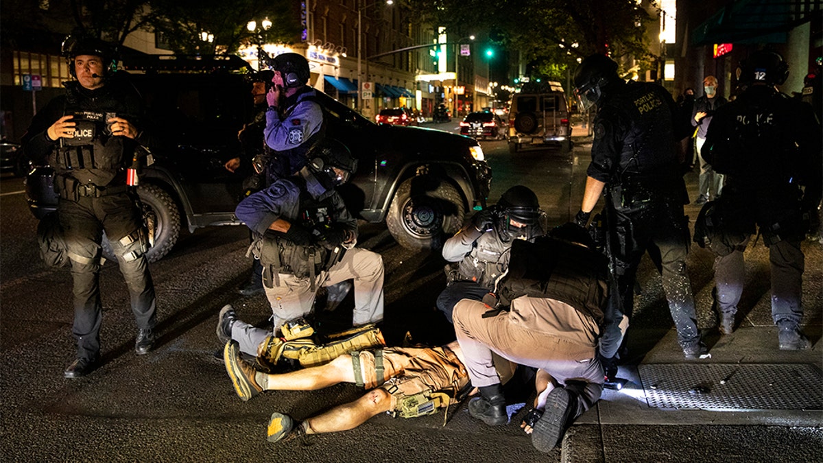 A man is treated after being shot Saturday, Aug. 29, 2020, in Portland, Ore. He later succumbed to his injuries. (AP Photo/Paula Bronstein)