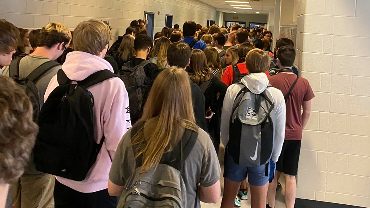 In this photo posted on Twitter, students crowd a hallway, Tuesday, Aug. 4, 2020, at North Paulding High School in Dallas, Ga. The 30,000-student suburban Paulding County school district in suburban Atlanta resumed classes Monday with 70% of students returning for in-person classes five days a week, days after the principal at North Paulding announced some members of the football team had tested positive for COVID-19. The district says it is encouraging mask use, but isn't requiring it. (Twitter via AP)