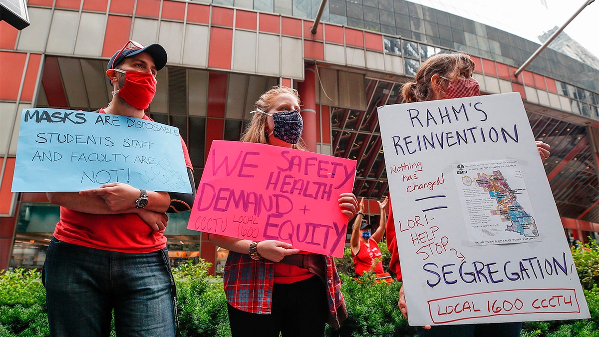 Protesters hold signs during the Occupy City Hall Protest and Car Caravan hosted by Chicago Teachers Union in Chicago, Illinois, on August 3, 2020. - Teachers and activists hold car caravan all over the country on August 3, 2020 to demand adequate classroom safety measures as schools debate reopening. 