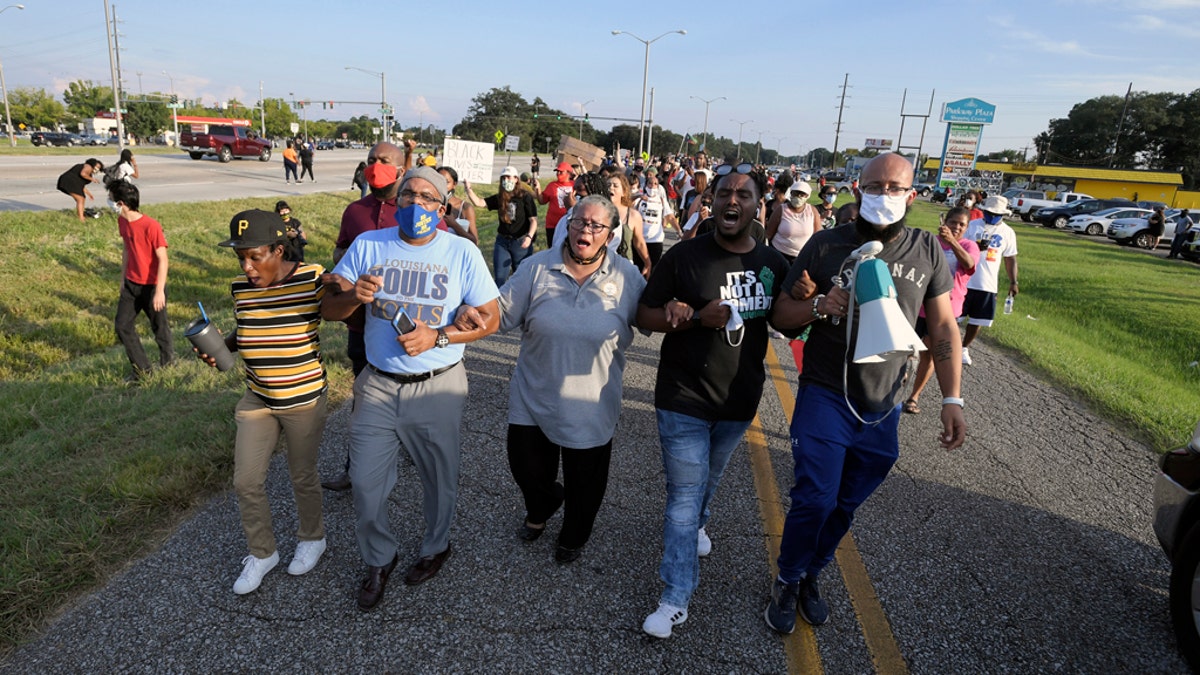 Marja Broussard, center, president of the Lafayette chapter of the NAACP, walking down Evangline Thruway with others demanding justice for Trayford Pellerin on Saturday in Lafayette, La.