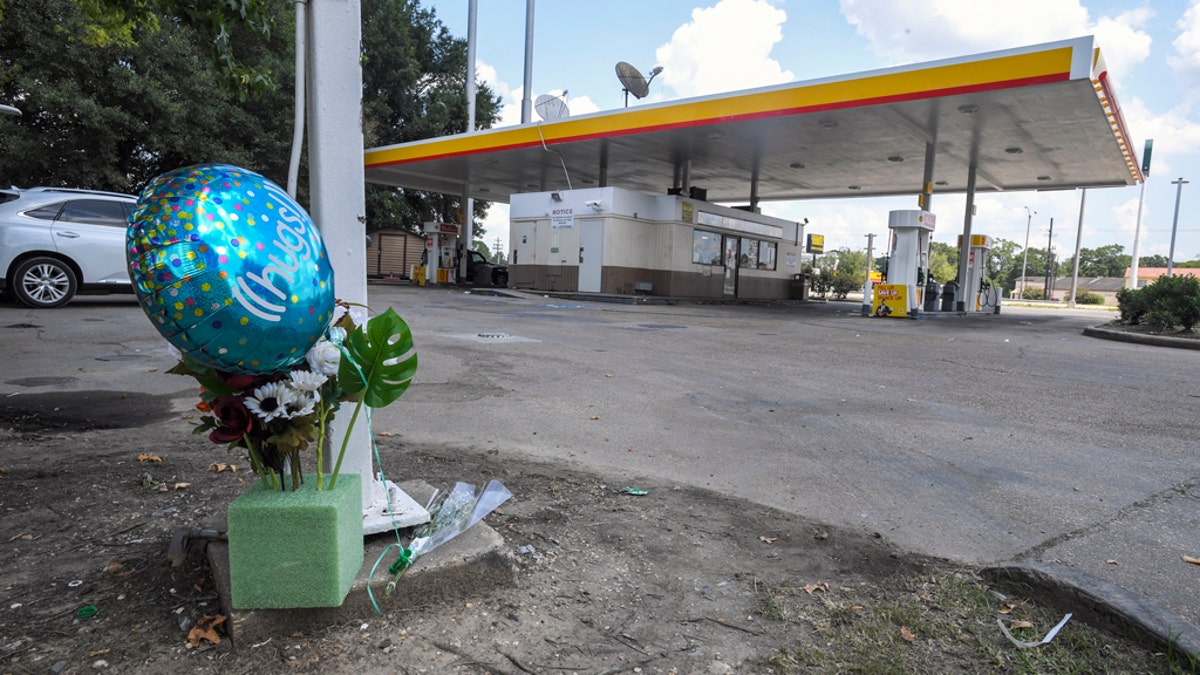 A makeshift memorial on the ground at a Shell station Saturday in Lafayette, La., for 31-year-old Trayford Pellerin.